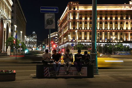 Men playing their smarthphones near the FSB headquaters in the night Moscow